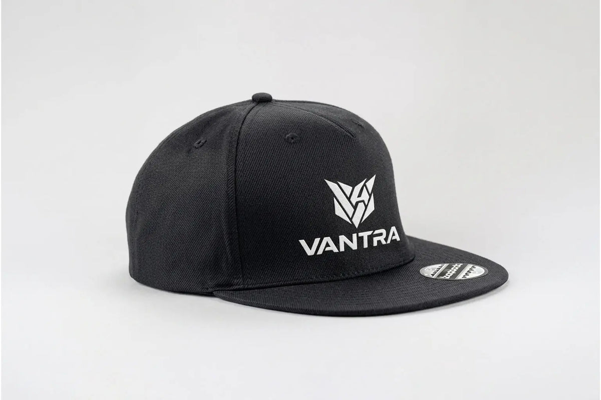 CAP KINGPIN VANTRA
Casquette snapback noire unie avec logo blanc VANTRA imprimé à l'avant, style urbain et minimaliste.