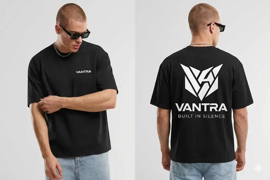 T-shirt oversize court noir VANTRA en situation de lookbook urbain, mettant en valeur la silhouette ample (boxy fit) et les graphismes blancs caractéristiques de la marque.